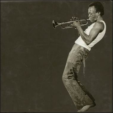 A person playing a trumpet
Description automatically generated