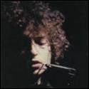 A person with curly hair holding a small object in his mouth
Description automatically generated