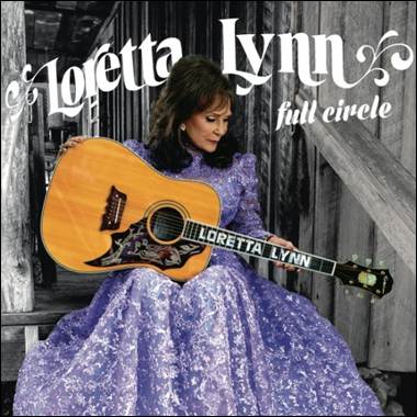 A person in a purple dress holding a guitar
Description automatically generated
