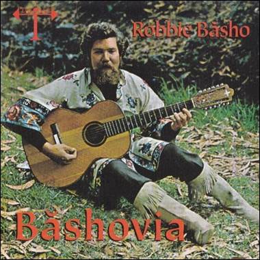 A person sitting on the grass playing a guitar

Description automatically generated