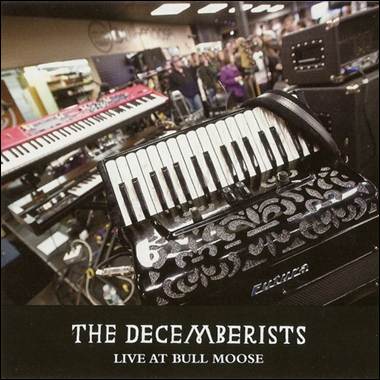 An accordion in a room with other musical instruments

Description automatically generated