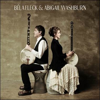 A person and person sitting on stools with musical instruments
Description automatically generated