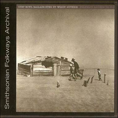 A person and child outside a wooden house
Description automatically generated