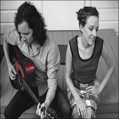 A person and person sitting on stairs playing guitar

Description automatically generated