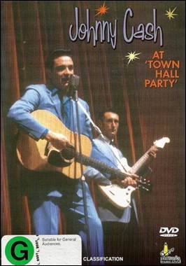 A person holding guitars and a microphone
Description automatically generated