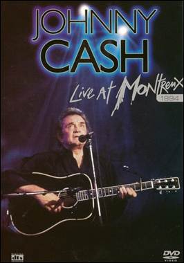 A person holding a guitar and singing
Description automatically generated