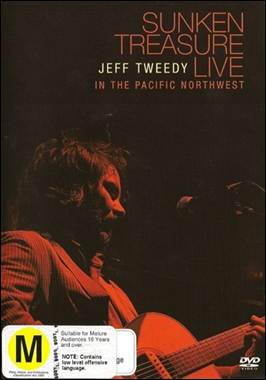 A person playing a guitar on a stage
Description automatically generated