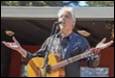 A person singing into a microphone with a guitar

Description automatically generated with medium confidence