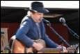 A person playing guitar and singing into a microphone

Description automatically generated with medium confidence