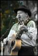 A person singing into a microphone with a guitar

Description automatically generated with medium confidence