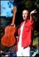 A person in a red shirt holding a guitar

Description automatically generated with medium confidence