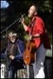 A person holding a guitar and singing into a microphone

Description automatically generated with medium confidence