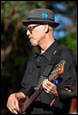 A person in a hat playing a guitar

Description automatically generated with medium confidence