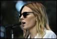A person wearing sunglasses and speaking into a microphone

Description automatically generated with medium confidence