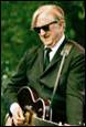 A person in a suit and tie holding a guitar

Description automatically generated with medium confidence