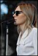 A person wearing sunglasses and speaking into a microphone

Description automatically generated with medium confidence