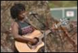 A person playing guitar and singing

Description automatically generated