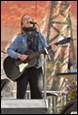 A person playing guitar and singing

Description automatically generated