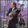 A person playing a guitar on a stage

Description automatically generated