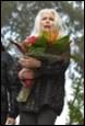 A person holding flowers in her hands

Description automatically generated