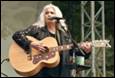A person playing guitar on stage

Description automatically generated