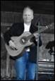 A person holding a guitar

Description automatically generated