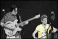 A person playing a guitar with another person

Description automatically generated with low confidence