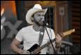 A person in a cowboy hat playing guitar

Description automatically generated with medium confidence