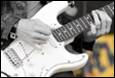 Close-up of a person playing an electric guitar

Description automatically generated