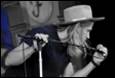 A picture containing microphone, concert, person, hat

Description automatically generated