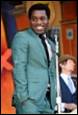 A person in a suit holding a microphone

Description automatically generated with medium confidence