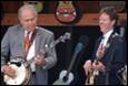 A person in a suit playing a banjo

Description automatically generated