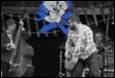 A person playing guitar on stage

Description automatically generated