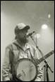 A person with a beard and a guitar

Description automatically generated