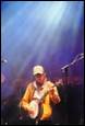 A person playing a guitar on stage

Description automatically generated