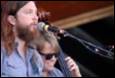 A person with a beard playing a cello

Description automatically generated