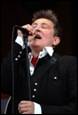 A person singing into a microphone

Description automatically generated
