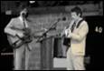 A couple of men playing instruments

Description automatically generated