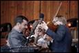 A person playing violin with another person in the background

Description automatically generated