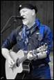 A person playing guitar and singing

Description automatically generated