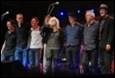 A group of people standing on a stage

Description automatically generated