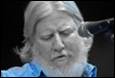 A person with a beard and a microphone

Description automatically generated