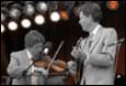 A person playing a violin and a person playing a violin

Description automatically generated