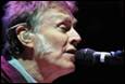A person with purple hair singing into a microphone

Description automatically generated