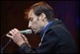 A person holding a microphone

Description automatically generated