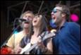 A group of people singing and playing guitar

Description automatically generated