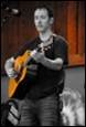 A person playing a guitar

Description automatically generated