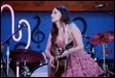 A person playing guitar on stage

Description automatically generated
