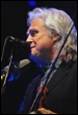 A person with white hair and microphone

Description automatically generated