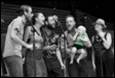 A group of people singing on stage

Description automatically generated